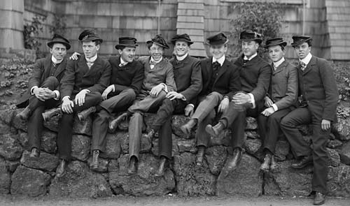 A group of men sitting on a stone wall in post-Civil War America.