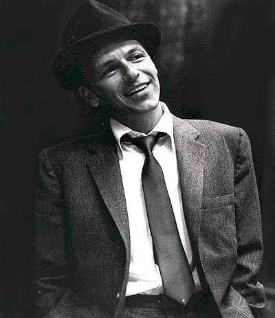 A black and white photo of a man in a suit and tie, reminiscent of Frank Sinatra.