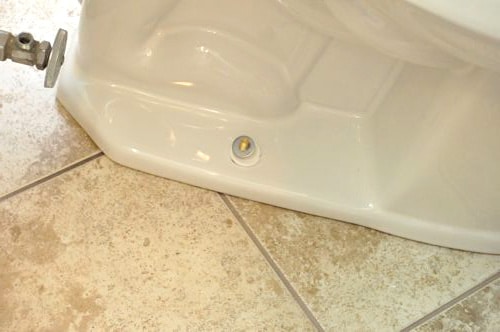 Installation of a new toilet adding washers nuts to closet bolt. 