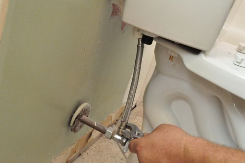 Attachment of a new toilet seat supply line using crescent wrench. 