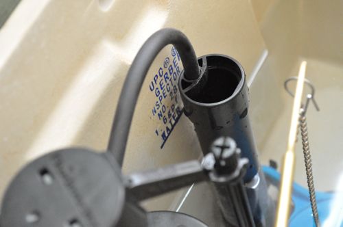 Adjusting a new toilet seat water tank fill level. 
