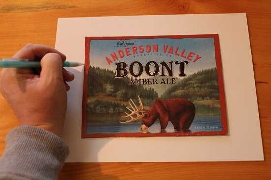 A man measuring the packet cover with pencil on paper. 