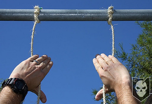 Man checking the tightness of the two ropes.