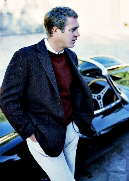 Steve mcqueen standing with car.