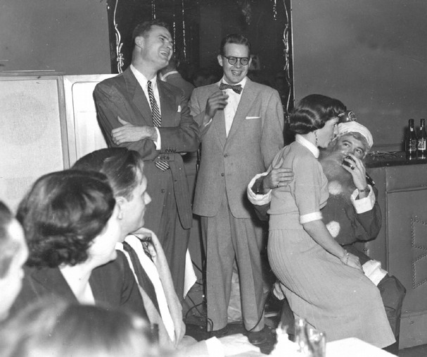 santa2 Vintage woman sitting on santa lap in holiday party.