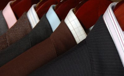 Wardrobe with suits close up photo wooden hangers.