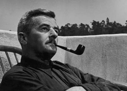 A man sitting in a chair enjoying his pipe.